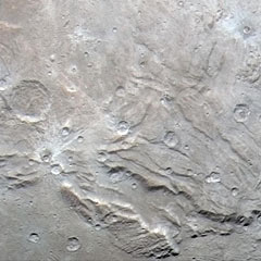 New Horizons closeup photo of Charon showing cracks and craters