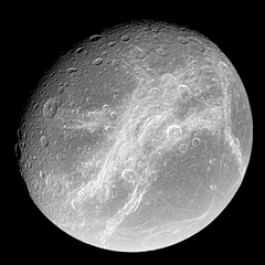 Cassini view of Dione showing whispy white ice fractures 