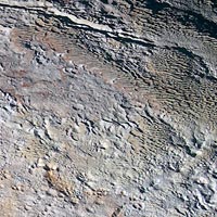Close-up image of Pluto showing rough textured mountains