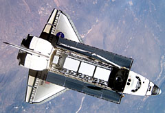 Image of space shuttle Atlantis in orbit above the earth