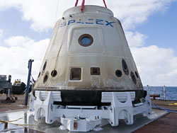 Image of the SpaceX Dragon C1 capsule on a barge as it makes the trip back to shore