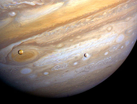 Image showing two of Jupiter's moons, Io and Europa, in orbit around the giant planet