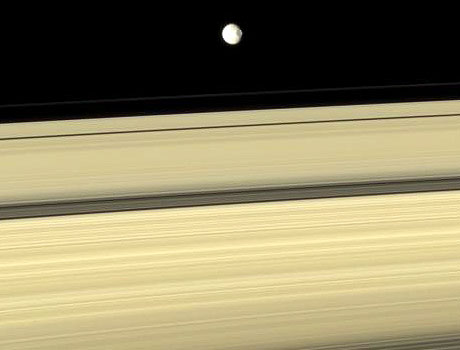 Image of Saturn's moon Mimas in orbit above the planet's rings